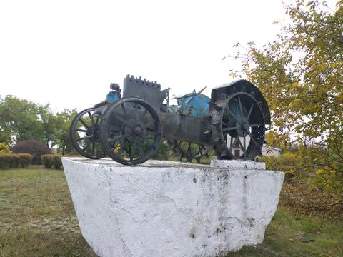 Monument to the first tractor and its drivers. Agricultural machinery Stock Photos