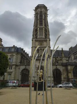 A monument to the head of a man in front of architectural buildings in Paris Stock Photos
