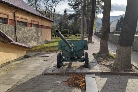 A monument, a machine gun from the Second World War, stands in a mountain town. Stock Photos