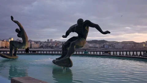 Monument to two surfers riding the waves on surfboards Stock Footage 209595098