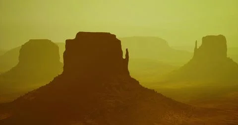 Monument Valley landscape during sunset in warm hues with silhouettes Stock Illustration
