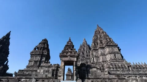 Monumental gateway frames the ornate towers and soaring spires of Prambanan.. Video stock 341542756
