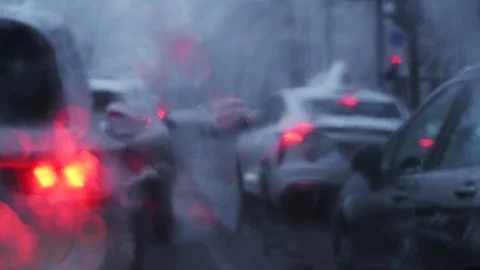 Moody 4K shot of congested urban traffic in snow, with glowing red brake li.. Stock Footage 325699578
