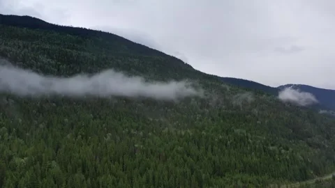 Moody Aerial View of Low Clouds Over Mountains and Forest Lake in British 스톡 동영상 334160791