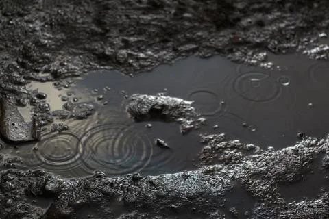 A moody and dramatic background of rainy soil ground. The defocused water rain Stock Photos