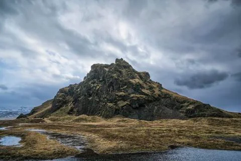 Moody and dramatic scene of a small hill along the Southern shore of Iceland Stock Photos