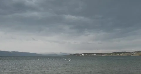 The moody atmosphere of Lake Sevan is palpable as clouds hover just above the Stockbeeldmateriaal 252467632