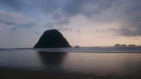 Moody beach at sunset Stock Photos