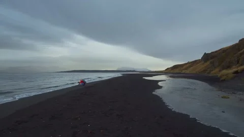 Moody Black Sand Beach and River Flowing into the Ocean in Iceland Stock Footage 320516243
