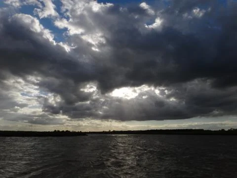 Moody clouds over river Foto stock