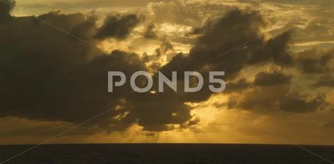 Moody clouds over the sea at sunset Stock Photos