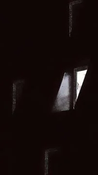 Moody dark interior with bright window and deep shadows Stock Photos