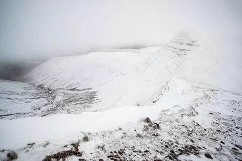 Moody dramatic low cloud Winter landscape in mountains with snow Stock Photos