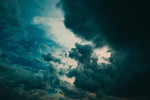 Moody, dramatic storm clouds sweep across a turbulent evening sky, creating.. Stock Photos