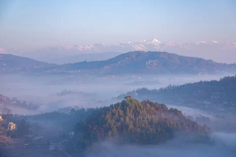 Moody Dramatic view of hills covered in fog and Great Himalaya Range in the b Stock Photos