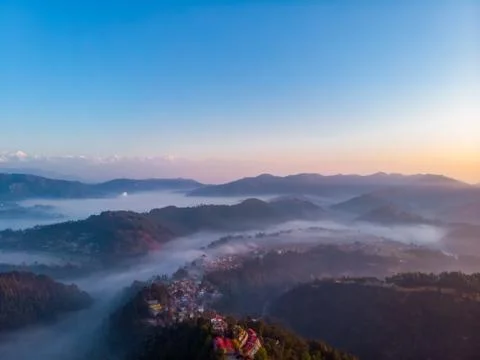 Moody Dramatic view of mountains covered in fog during sunrise with Great Him Stock Photos