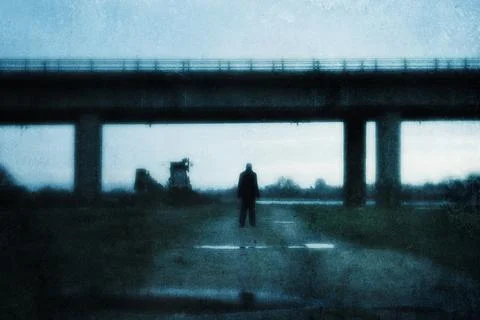A moody figure, back to camera. Standing under a bridge Stock Photos