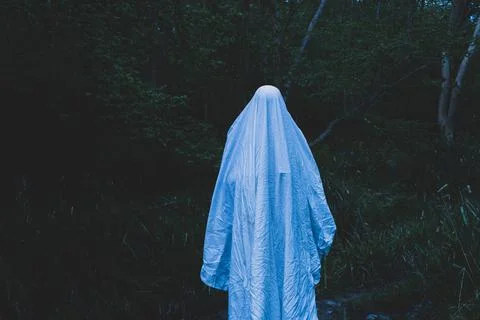 A moody horror edit of a ghost with a sheet over it's head. Stock Photos