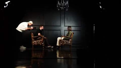 Moody indoor studio interview setup with cameraman and people talk face to Video stock 270447820
