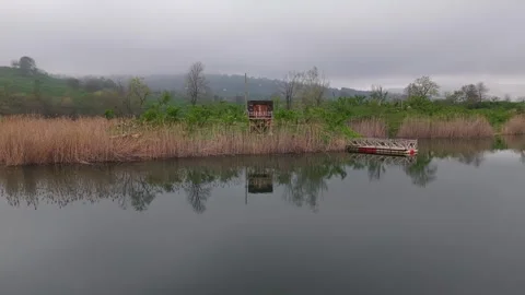 Moody Lake Reflection 4K 60fps Drone Low Flyover Pier Reeds Vídeo Stock 335598992