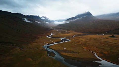 Moody landscape featuring a winding river cutting through a vast, open valley. Stock Footage 297364667