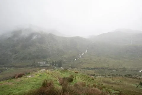 Moody landscape image of low cloud hanging over Snowdonia mountain range afte Stock Photos