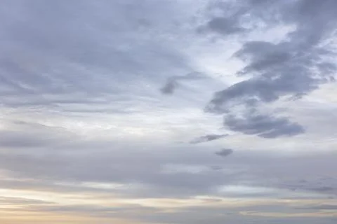 Moody Layers of Grey Clouds in Sky at Dusk with Soft Warm Orange Light Stock Photos