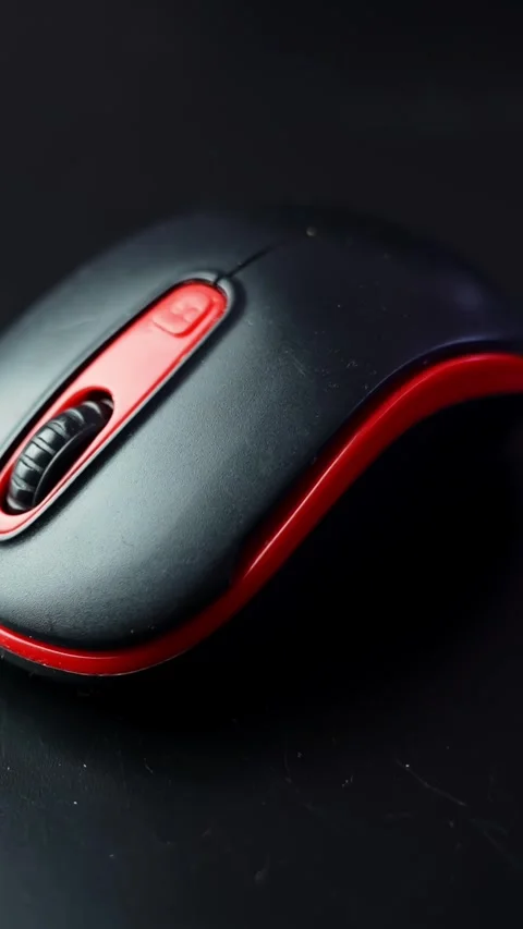 Moody macro shot of a black and red computer mouse on a dark desk with copy Stock Footage 329002408