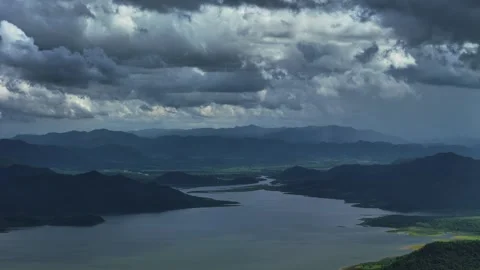 Moody mountain lake view with layered hills under heavy cloud cover Vídeo Stock 314817495