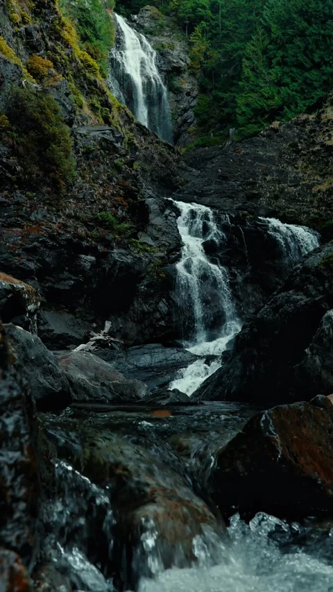 Moody Mountain Waterfall Flowing Down Rocky Cliff (Vertical) Stock Footage 337665877