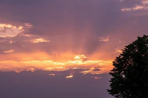 Moody orange sunset between the clouds sky Stock Photos