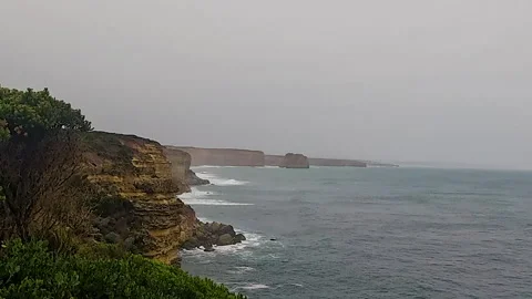 Moody Sea Cliffs and Distant Rock Stacks on Overcast Day Stock Footage 337635057
