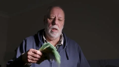 Moody Senior Man Fanning Stack of Green Money Indoors Stock Footage 345271841