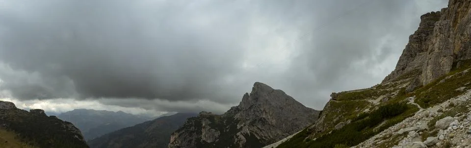 Moody storm clouds above dramatic Dolomites peaks and rugged alpine mountai.. Stock Photos