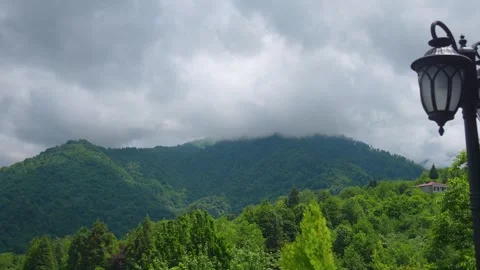 Moody storm clouds moving over green mountain forest Stock Footage 342077642