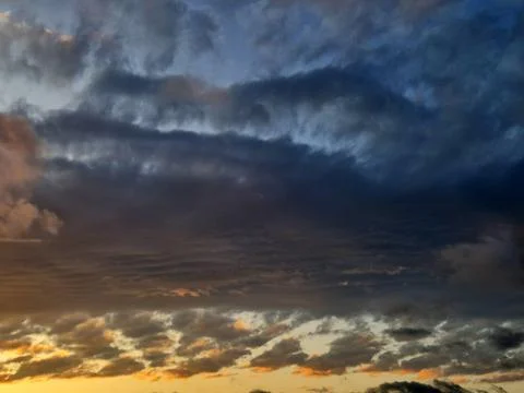 Moody sunset clouds with dramatic sky and warm horizon light Stockfoto's