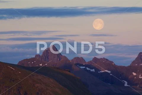 Moon above rocky peaks Stock Photos