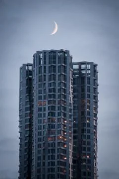 Moon above skyscraper Stock Photos