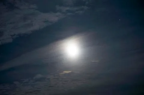 The moon among the clouds at night. Stock Photos