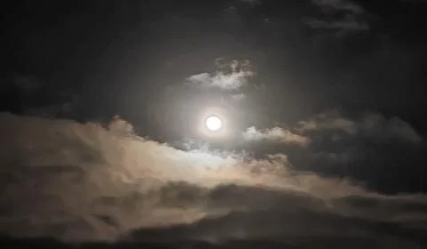 Moon among clouds Stock Photos