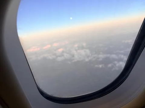Moon and clouds seen from an airplane window. Stock Photos