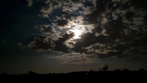 Moon behind the clouds in the dark night Stock Photos