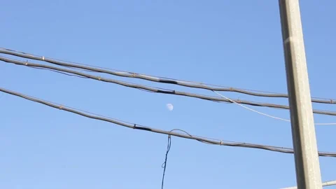 Moon is in the blue sky between the wires 스톡 동영상 131673625