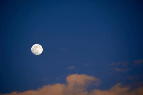 Moon in blue sky with white clouds Stock Photos