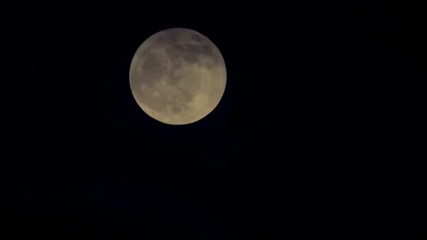 The moon coming out from behind clouds at black night sky Stock Footage 100228187