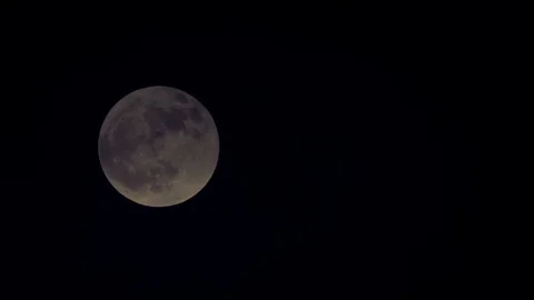 The moon coming out from behind dark clouds at night sky Stock Footage 100200425