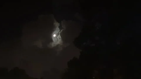 The moon is covered by dark clouds at night 스톡 동영상 300314194