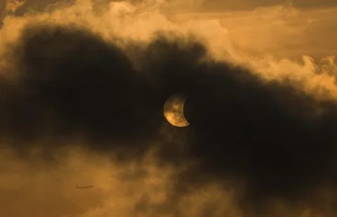 The Moon covering the Sun in a partial eclipse with dramatic cloud. Scienti.. Stock Photos