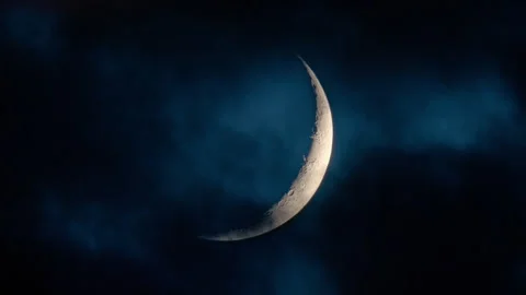 Moon crescent with clouds rolling by in the night sky Stock Footage 340778650
