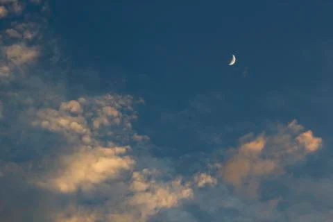 Moon on dramatic sunset sky with clouds Stock Photos